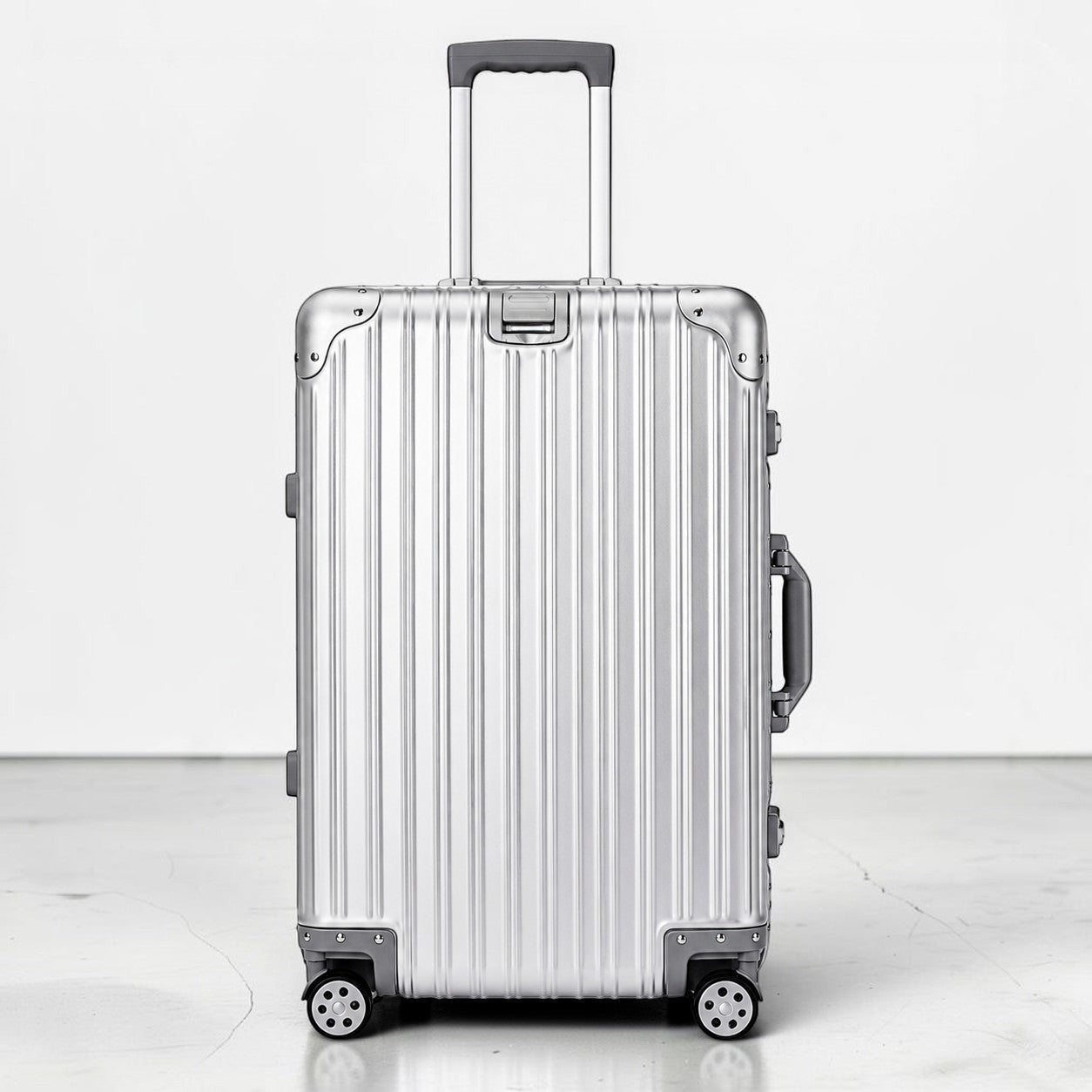 CASE.01 aluminum suitcase with retractable handle and four spinner wheels. Silver ribbed exterior with black accents.