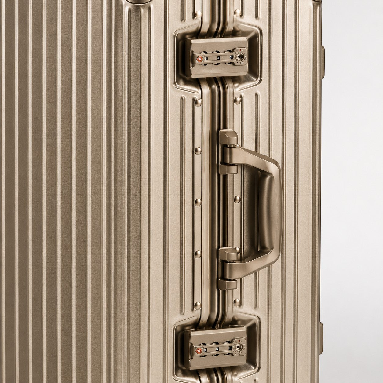 CASE.01 aluminum suitcase in champagne gold with TSA-approved locks and a retractable handle.