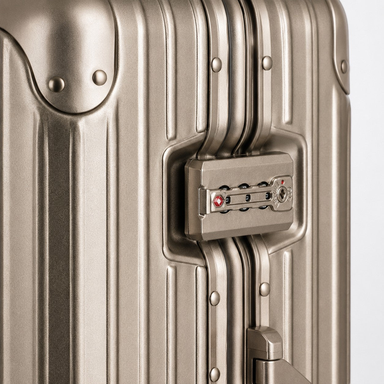 CASE.01 aluminum suitcase in champagne gold with TSA combination lock and ribbed exterior.
