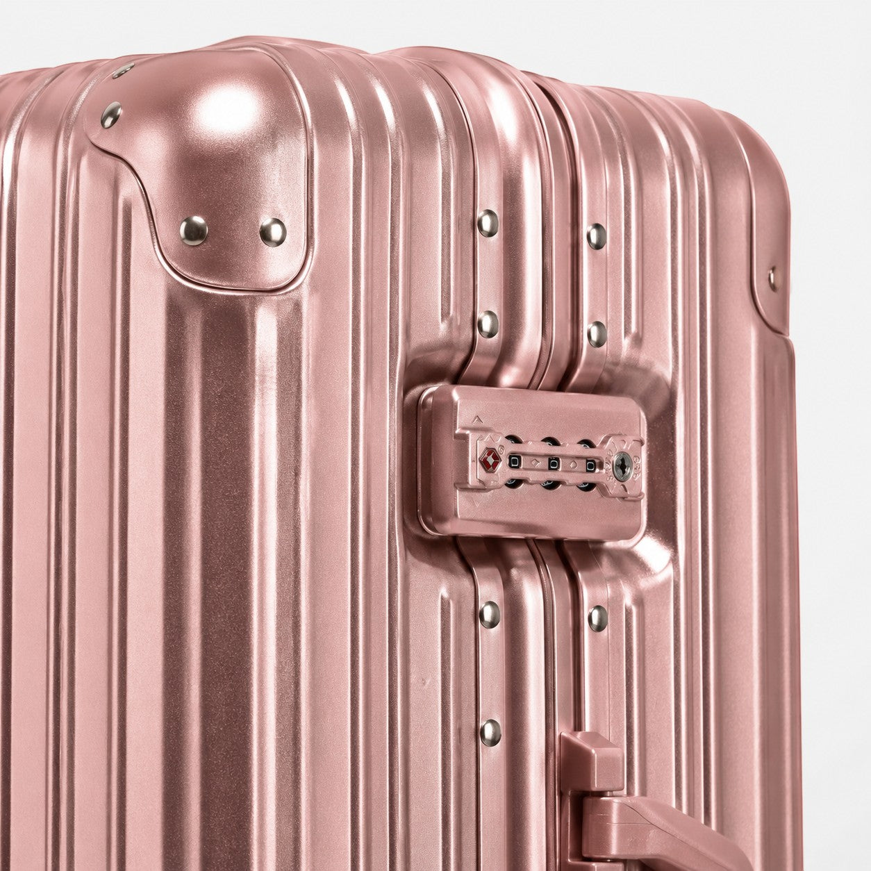 CASE.01 aluminum suitcase in rose gold with TSA combination lock and riveted corners.