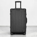 CASE.01 aluminum suitcase in black with ribbed texture, telescopic handle, and spinner wheels.