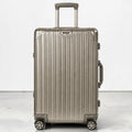 CASE.01 aluminum suitcase in champagne with telescopic handle and four spinner wheels. Minimalist design.